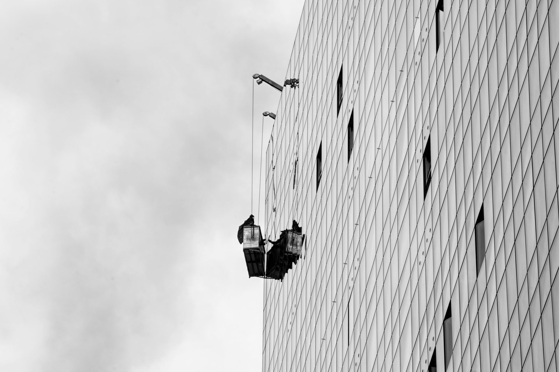 Bauarbeiter an Gebäudewand hängend